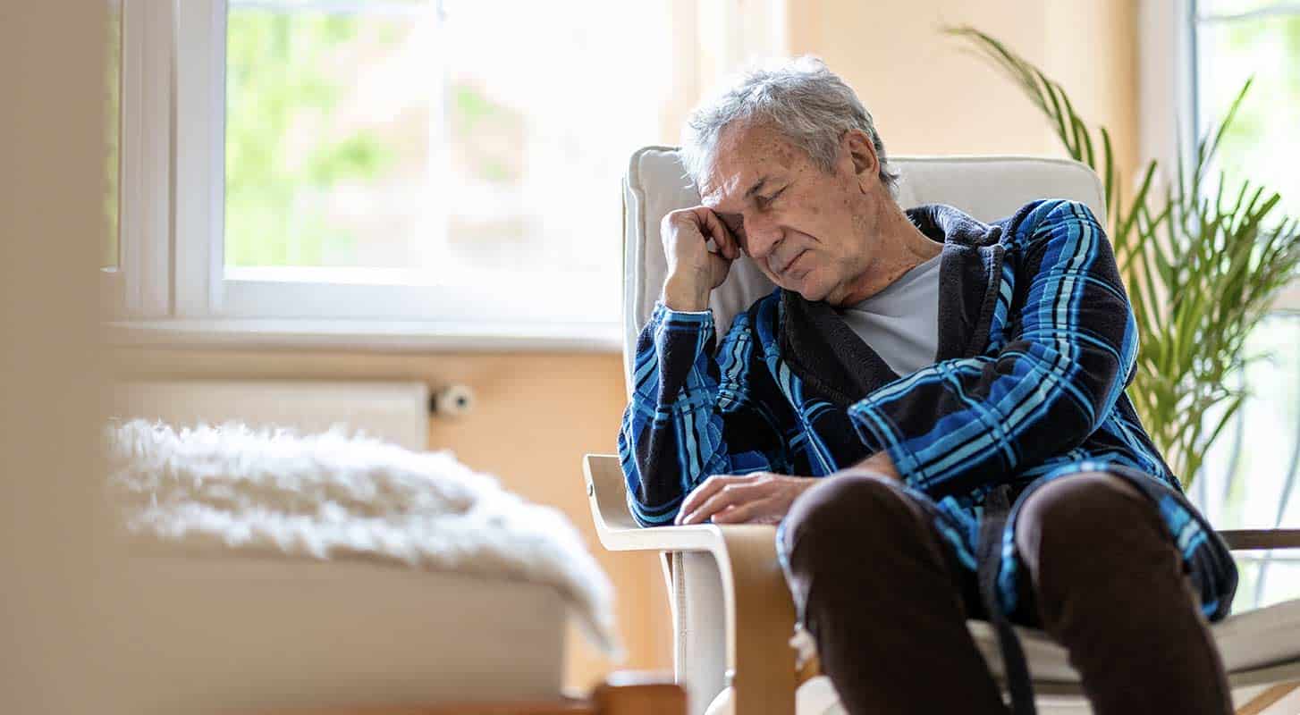 Elderly person rests fatigued at nursing home.