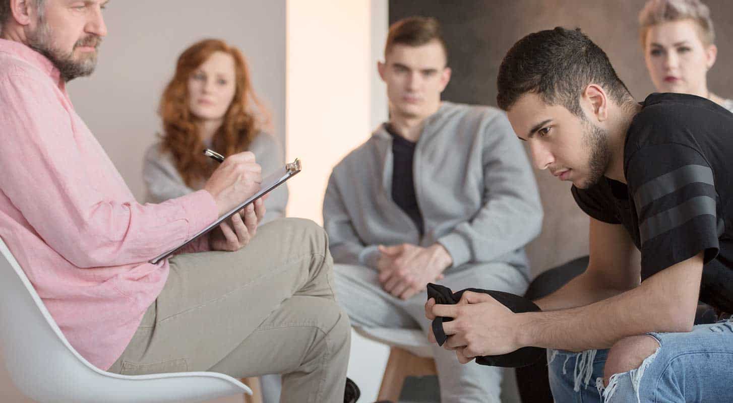 Young man listens while participating in therapy session
